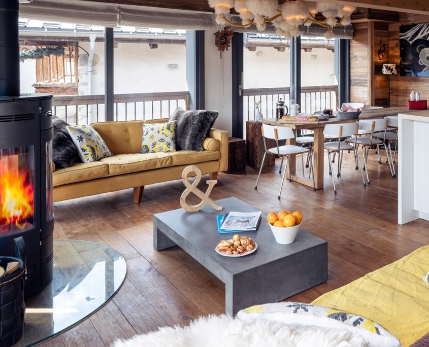 Chalet living room with coffee table, sofas and large windows and wood burner, in Courchevel