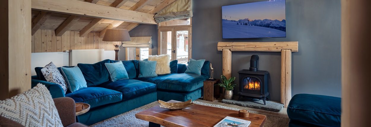 Chalet Chu Lo Dou living room 1250px Luxurious chalet living room with colourful sofas, wooden beams and a log fire