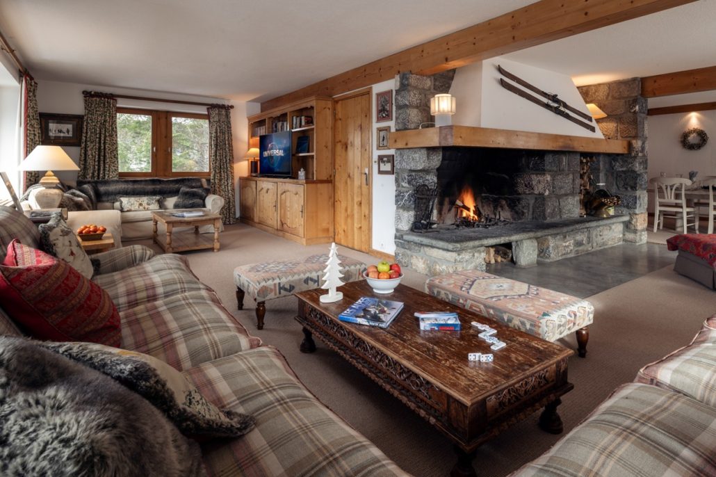 The Best Family Ski Resorts in France for Magical Winter Memories 7 Interior of Chalet Loden, Meribel, showing huge fireplace, sofas and TV