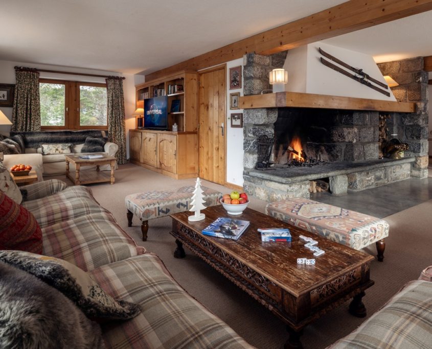 Interior of Chalet Loden, Meribel, showing huge fireplace, sofas and TV