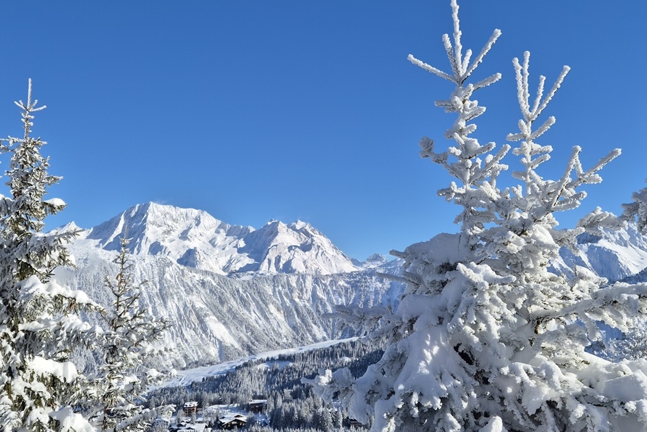 Snowy trees and Courchevel France in background on Christmas Eve 2024