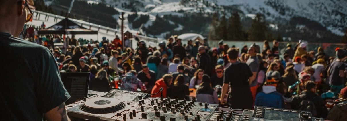 Guide to après-ski in Meribel 1 DJ Bubble and Crisp at the Ronnie in Meribel. Decks in foreground, with crowd on the terrace and snow-capped mountains in background