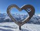Meribel Centre: Your Guide to the Heart of the Three Valleys 13 Meribel heart sculpture seat with snowy mountains in the background