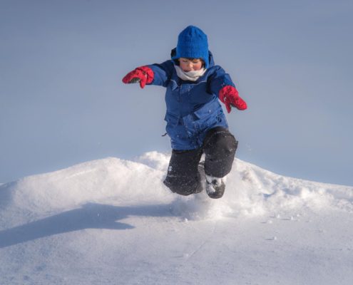 Kind springt Schnee