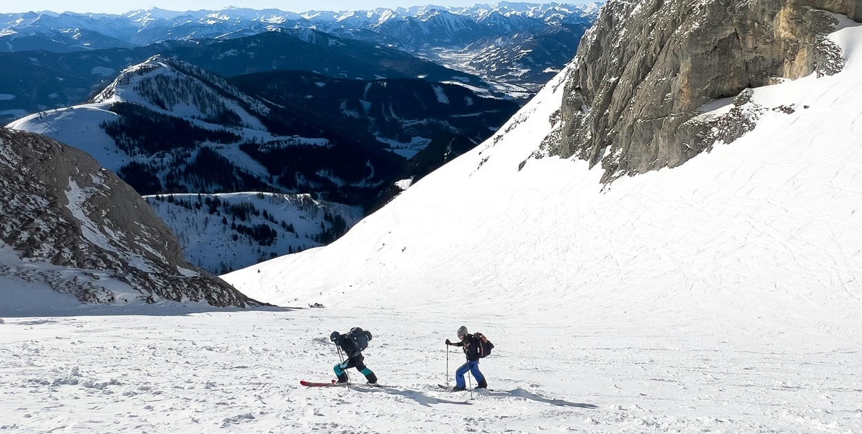 Advanced ski touring techniques on a steep mountain slope.