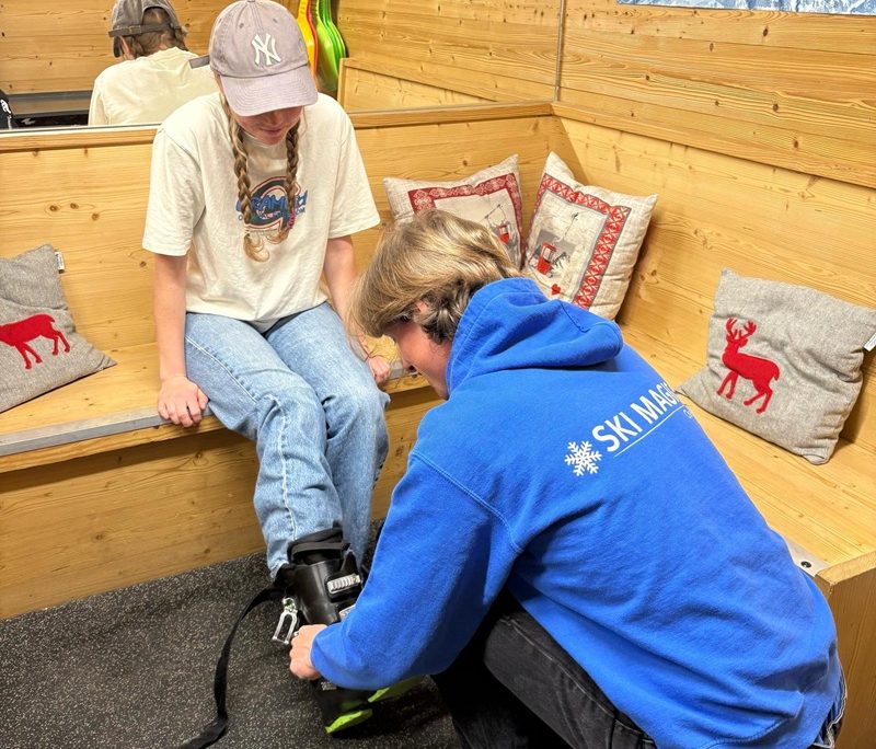 Ski technician fitting hire ski boots for a guest in a La Tania chalet